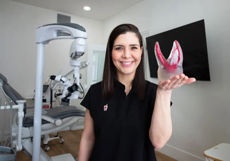 Dr. Jacqueline Lopez Gross holding a tooth model