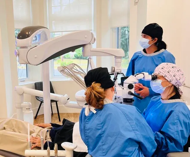 Endodontist and assistants working with the operating microscope